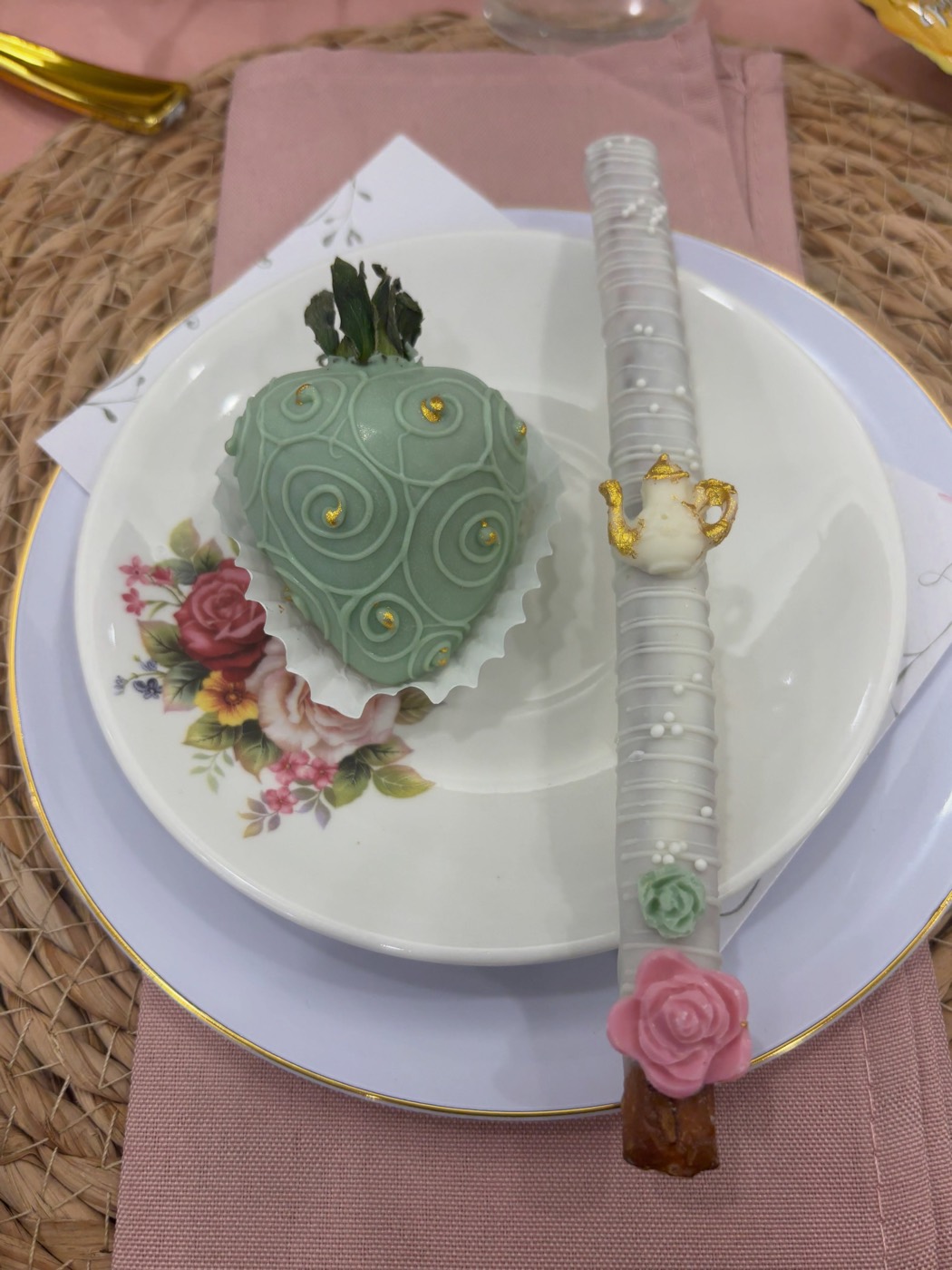 A sage chocolate-covered strawberry on vintage floral china